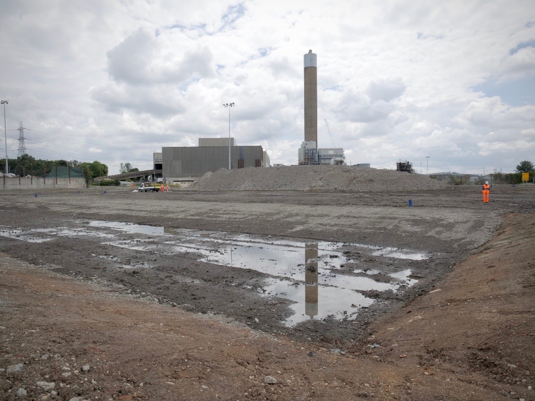 View of the site looking south. A large mound of rubble remains onsite and will be repurposed for construction of the replacement facility.